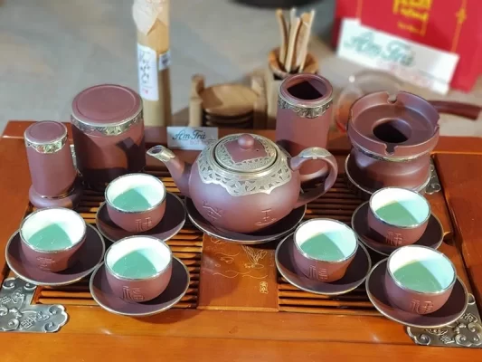 Bộ trà nâu với chén lót và phụ kiện bày trên khay